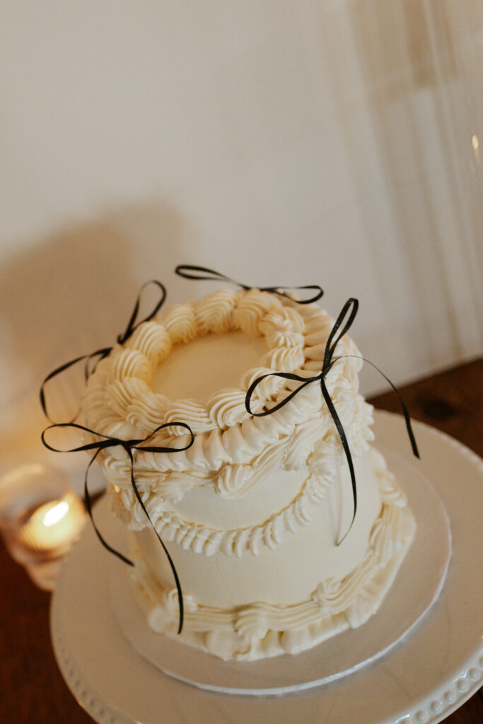 white wedding cake with bows on it taken by Hematite Images wedding photographer